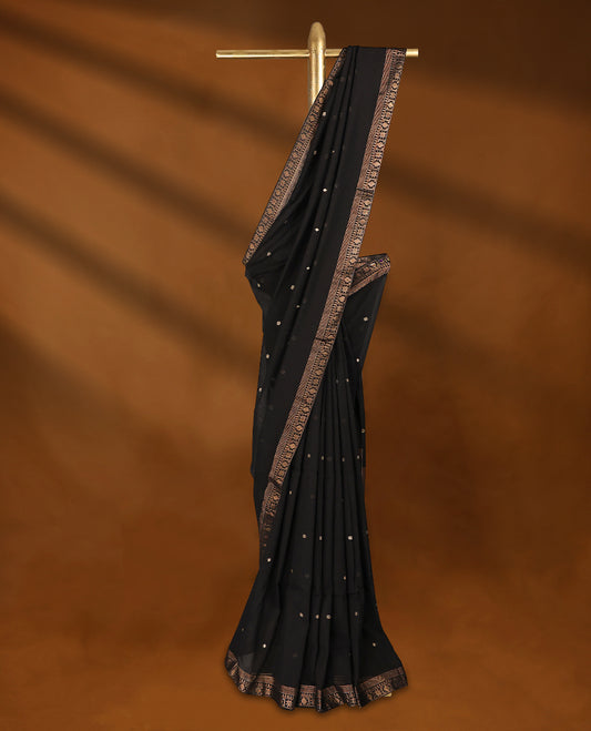 Black colour soft khadi cotton saree with small Beige Zari Flower motifs on the body, detailed woven Gold zari border, paired pallu with tussles, with matching blouse.