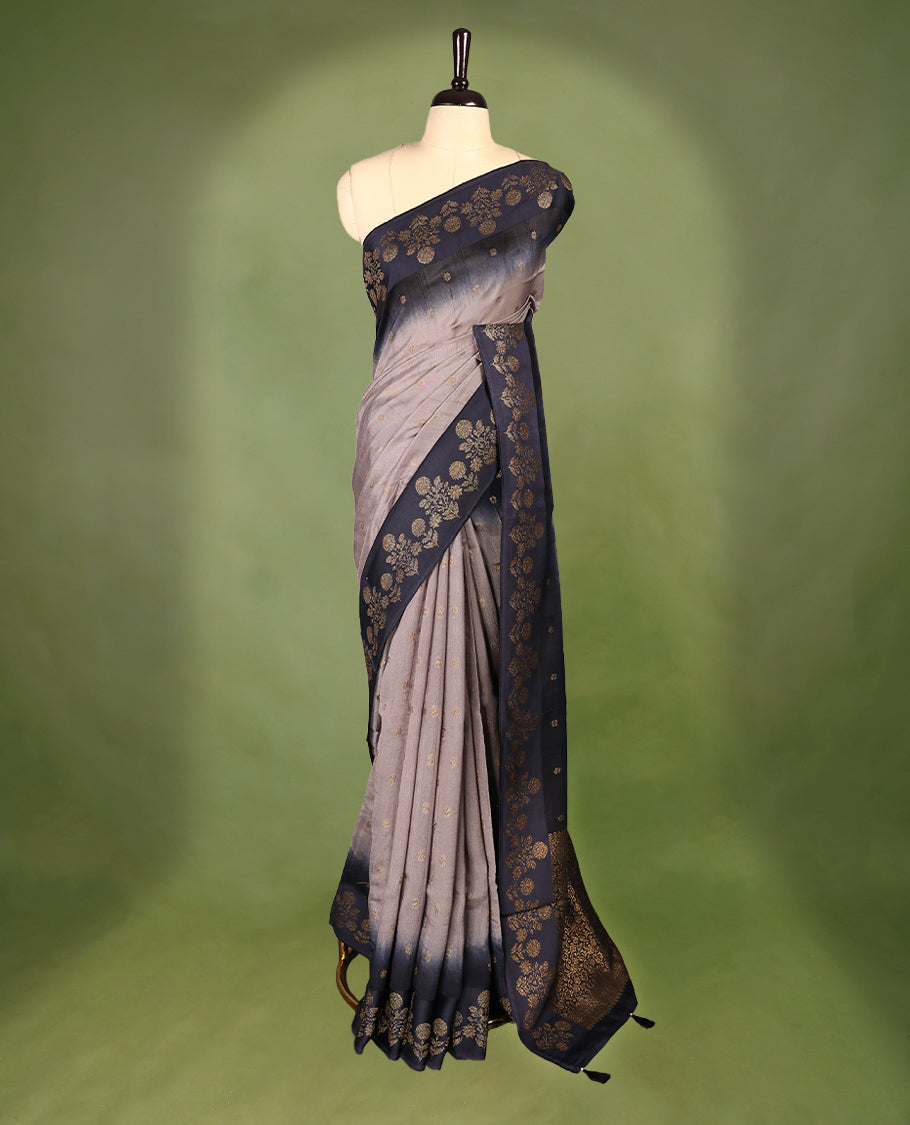 Grey and dark blue double shade semi Banaras Tussar Georgette saree adorned with elegant antique gold zari floral motifs across the body, featuring a detailed woven border and grand pallu, paired with a matching blouse piece.