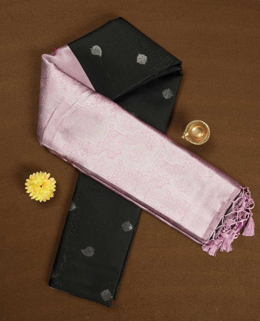 Black colour semi silk saree adorned with subtle silver zari motifs on the body, complemented by a pastel pink pallu intricately woven with rich floral patterns border and pallu, and paired with a matching blouse