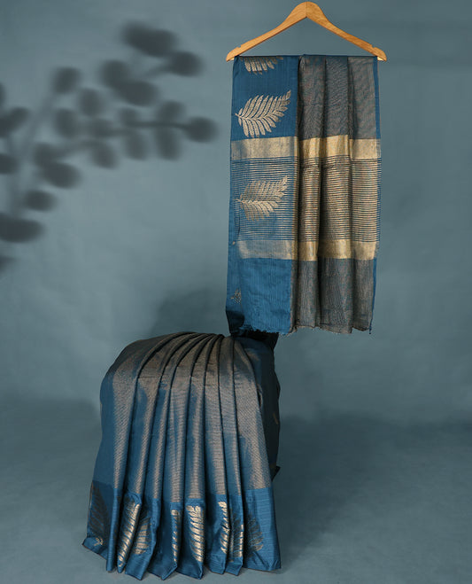 Blue Colour Semi Tussar Silk saree featuring golden zari horizontal lines across the body, adorned with bold Leaf motifs on the border, paired with a matching blouse.
