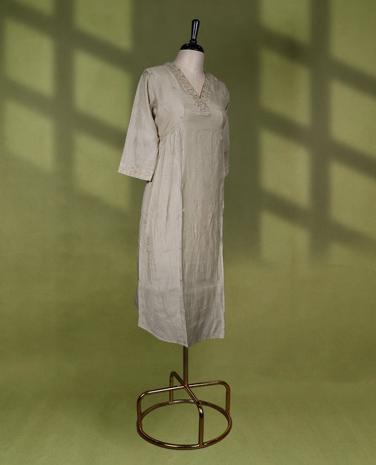 Beige colour Readymade kurti with embroidery and small thread buttas for women, featuring 3/4 sleeves.