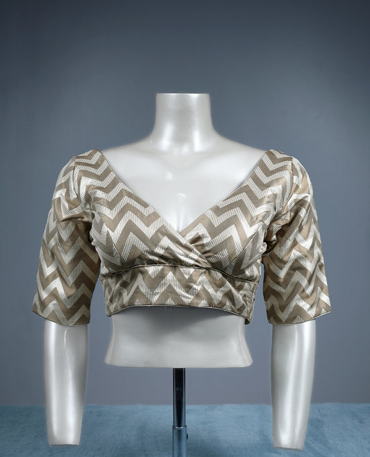 Beige and cream V neck padded readymade blouse featuring a bold chevron pattern with elbow length sleeves, crafted in a glossy fabric for a stylish, contemporary ethnic look.