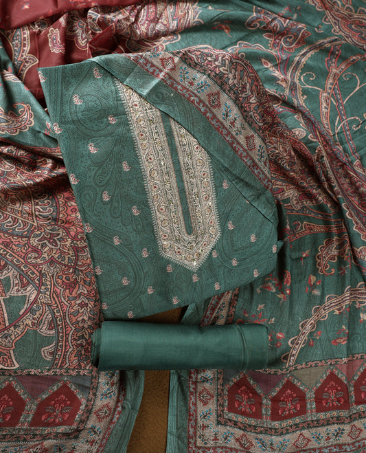 Pine green colour churidhar material featuring intricate paisley prints and delicate embroidery, paired with a plain matching bottom and a printed dupatta.