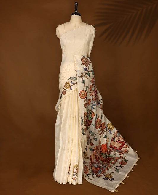 Elegant off white colour Kota net saree featuring intricate hand painted Kalamkari motifs on the pallu and floral accents on the pleats, blending tradition with artistry & Perfect for festive occasions and graceful styling.