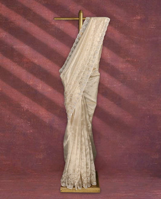 Beige colour pure organza saree featuring sequin work all over the body, adorned with a heavily embellished border with beads, stones, and sequins, complemented by a worked pallu and paired with a matching embellished blouse