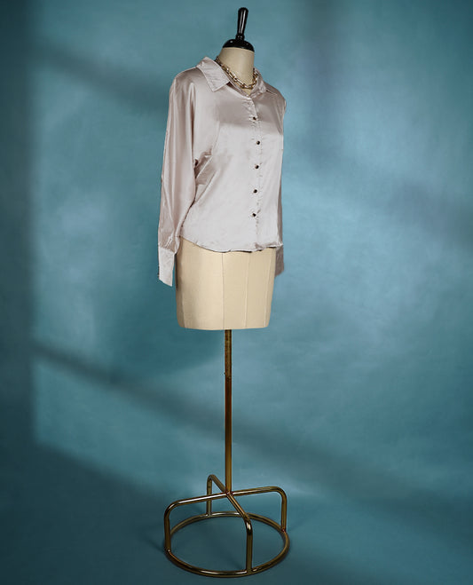 Champagne satin shirt featuring a collared neckline and button down front, designed with long sleeves and a relaxed fit