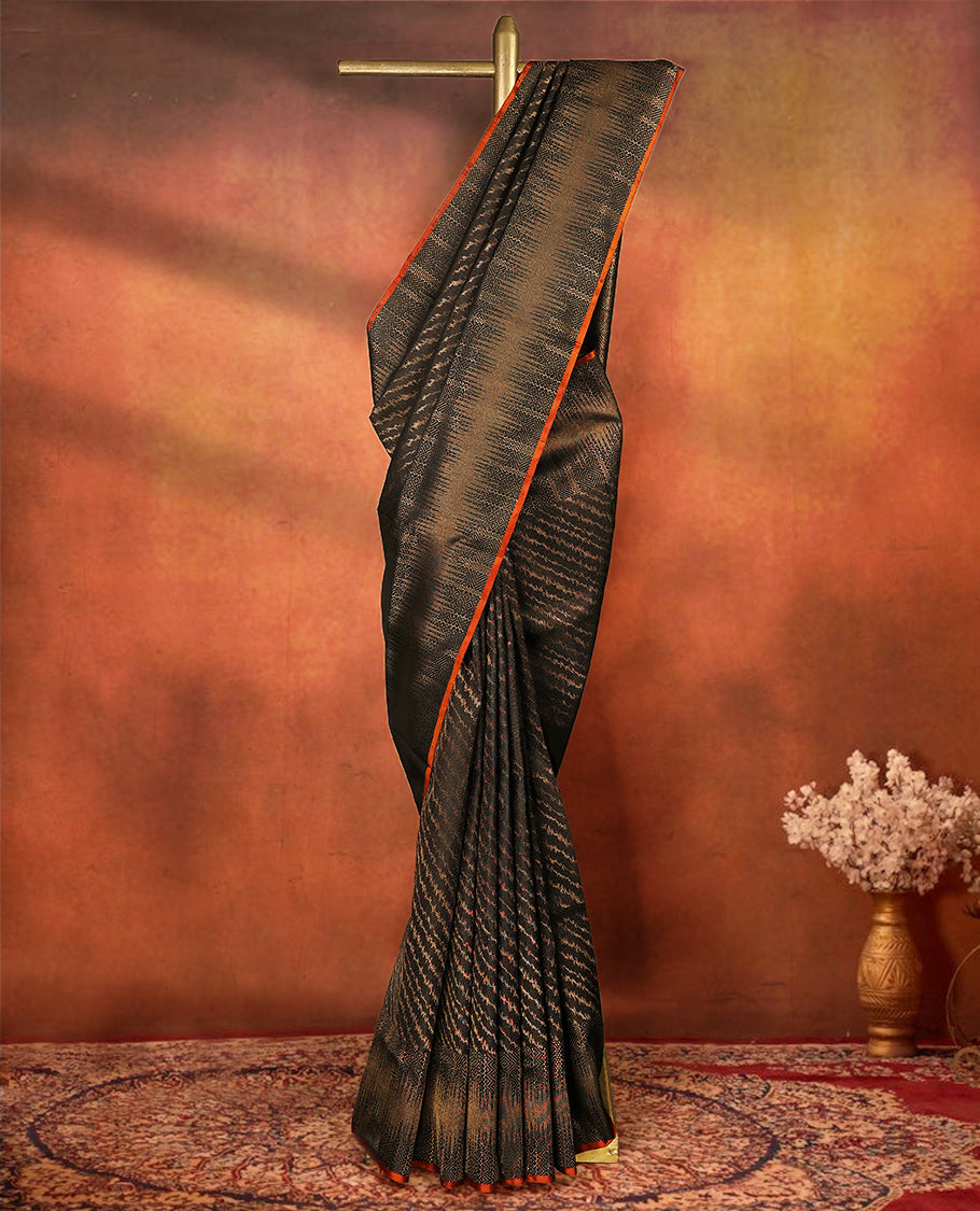 Deep black colour pure Mayuri silk saree featuring finely woven Golden zari motifs across the body, detailed with a subtle geometric self border with intricate texture, with matching blouse