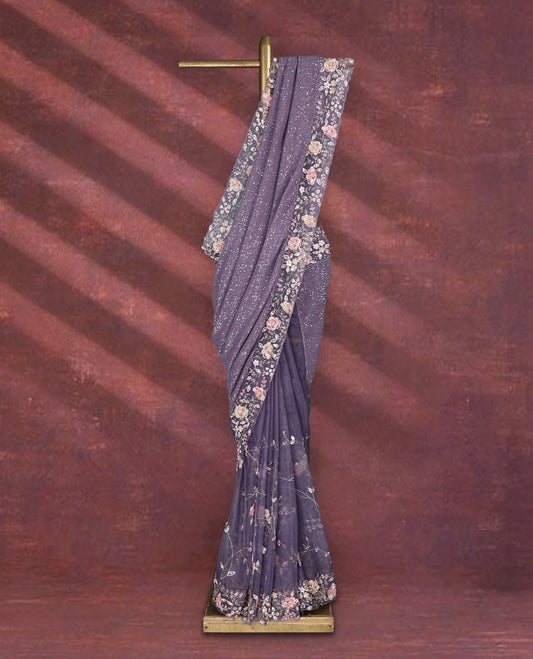 Pastel purple colour pure organza saree featuring all over sequin work, adorned with a matching floral kodi intricately worked border, complemented by a richly worked pallu and paired with a heavily embellished matching blouse.