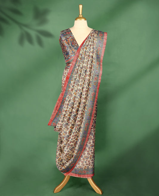 Ivory cream colour Manipuri saree showcases a body adorned with vibrant paisley and floral block motifs, framed by a contrasting blue floral printed border with red piping, and paired with a matching blouse.