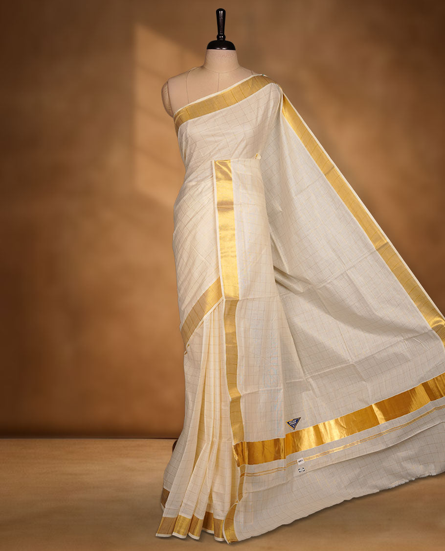 Off-white colour cotton Kerala saree featuring a classic gold kasavu border, highlighted by subtle woven check patterns across the body and pallu, and paired with a matching blouse.