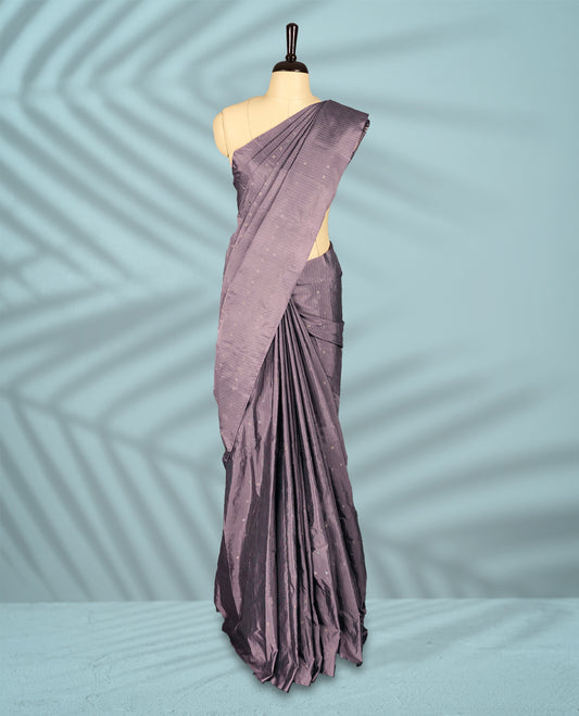 Greyish Purple colour semi silk saree features a subtle checkered pattern woven with delicate threadwork across the body, crafted without a border and paired with a matching blouse