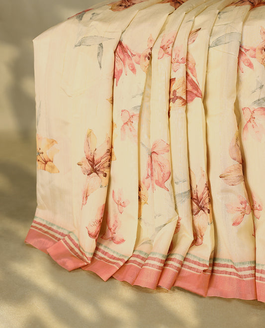 Cream colour semi silk printed saree adorned with soft Peach floral motifs across the body, finished with a Peach and green striped border, with matching blouse