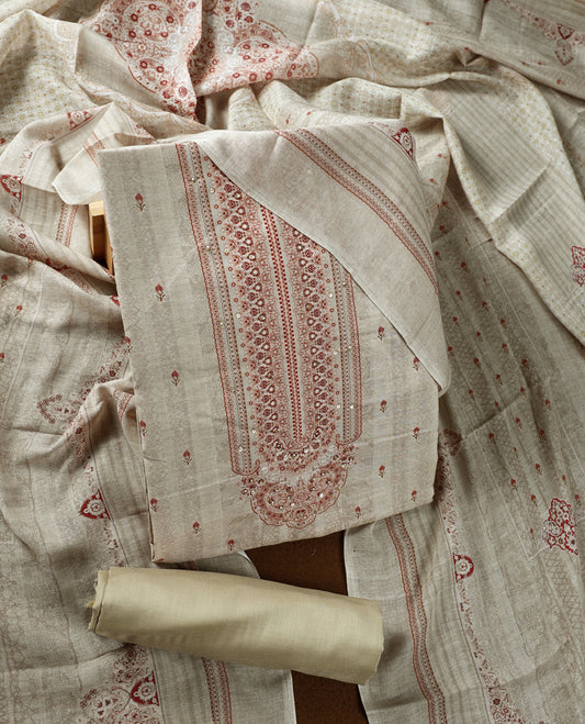 Beige colour churidhar material adorned with subtle printed motifs and sequin highlights, paired with a plain matching bottom and a printed dupatta.