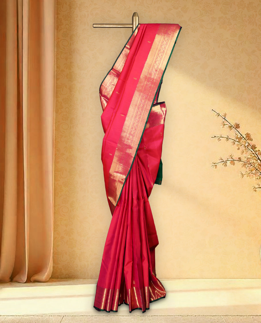 Rani pink pure Kancheepuram saree with gold zari paisley motifs on the body traditional border with floral kodi pattern and green piping, grand pallu with diamond motifs paired with matching blouse