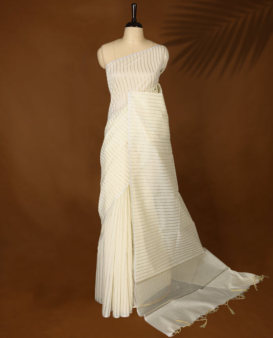 Light gold colour Organza Kerala saree featuring Silver zari stripes on the body, without border, Comes paired with a coordinated matching blouse.