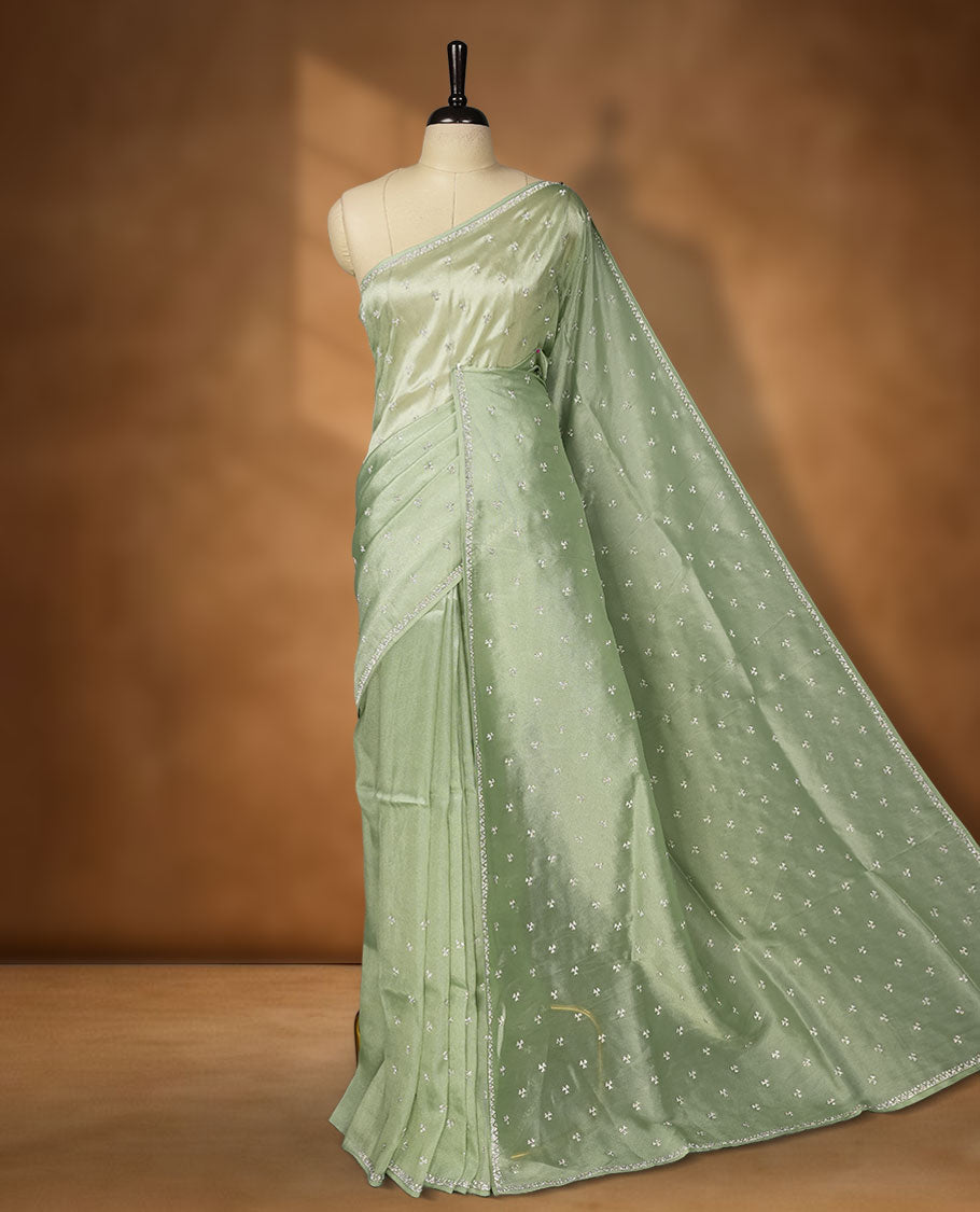 Pastel Mint colour net shimmer fancy saree adorned with white stone buttas all over the body, paired with a delicate stone worked border, with matching blouse