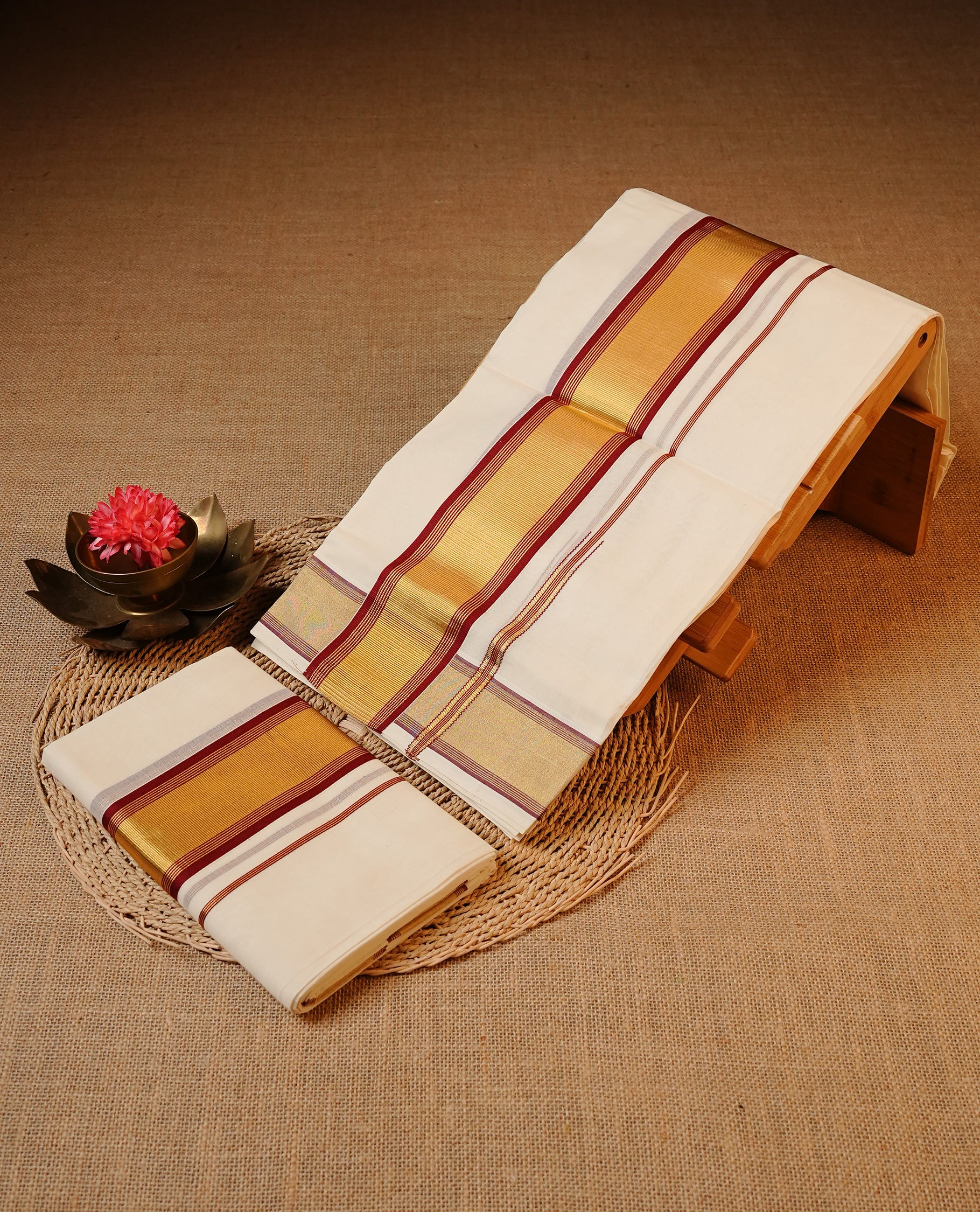 Off white colour Cotton Set Mund featuring a plain body, enhanced by a gold zari border with Maroon stripes.