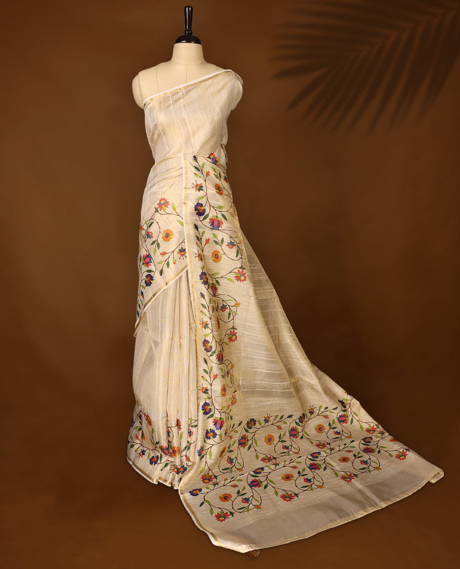 Graceful off white colour organza Kerala saree with vibrant multicolor floral embroidery and a soft golden sheen, Lightweight and elegant, ideal for festive occasions & Comes with a matching blouse piece.