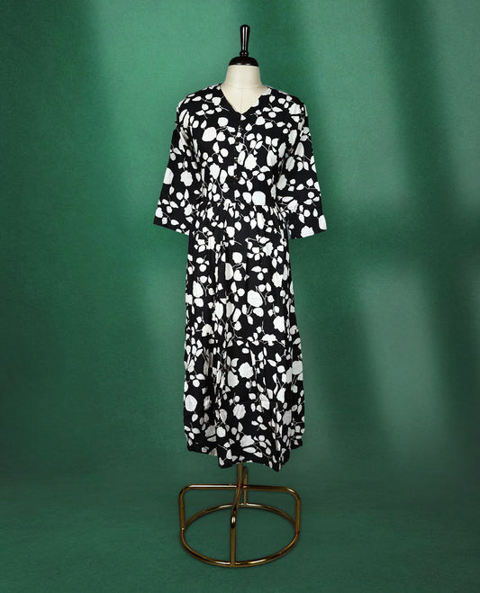 Black rayon kurti featuring bold white floral prints, designed with a V neckline, front button detailing, and a gathered waist, breezy and modern choice for casual wear.