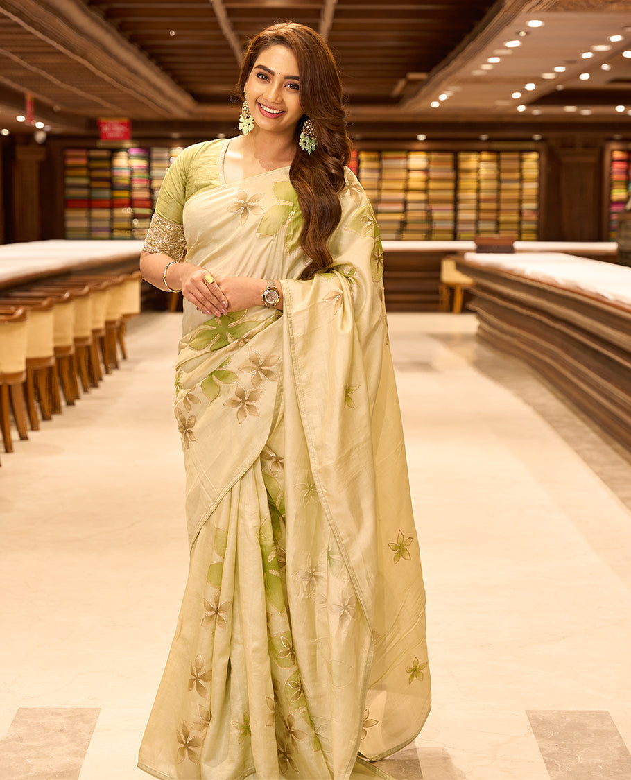 Light pastel green colour pure tussar silk saree featuring elegant hand painted floral designs, beautifully highlighted with subtle gotta work, paired with a matching blouse.