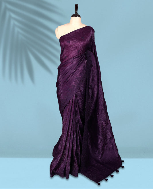 Deep Grape Colour crush soft silk saree boasts a lustrous crinkled texture with subtle self colored floral Motifs on the body and an elegant Floral thread cutwork border, paired with a matching blouse.