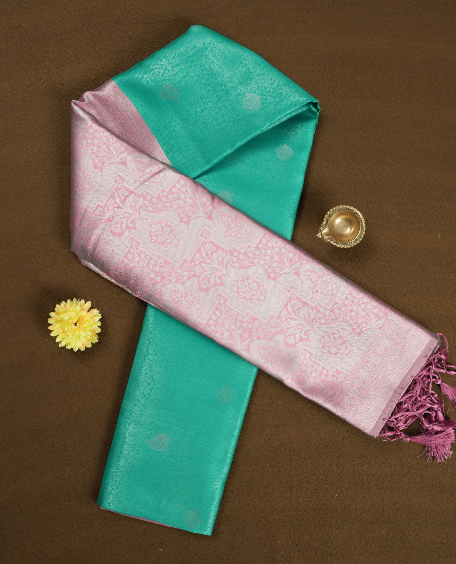 Aqua green colour semi silk saree adorned with subtle silver zari motifs on the body, complemented by a pastel pink pallu intricately woven with rich floral patterns border and pallu, and paired with a matching blouse