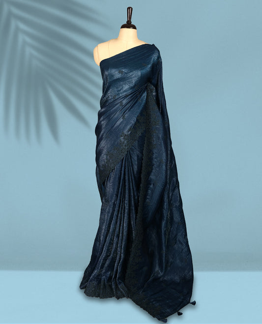 Midnight Blue Colour crush soft silk saree boasts a lustrous crinkled texture with subtle self colored floral Motifs on the body and an elegant Floral thread cutwork border, paired with a matching blouse.