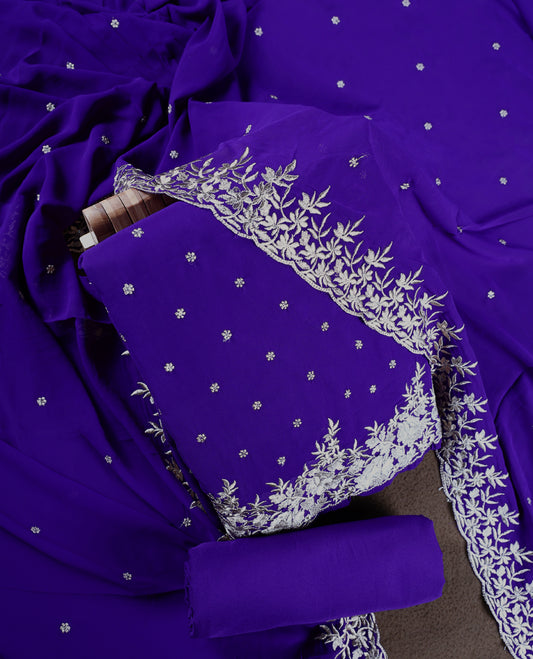 Indigo colour churidhar material adorned with silver floral embroidery and scattered butti work, complemented by a plain matching bottom and an elegant embroidered dupatta.