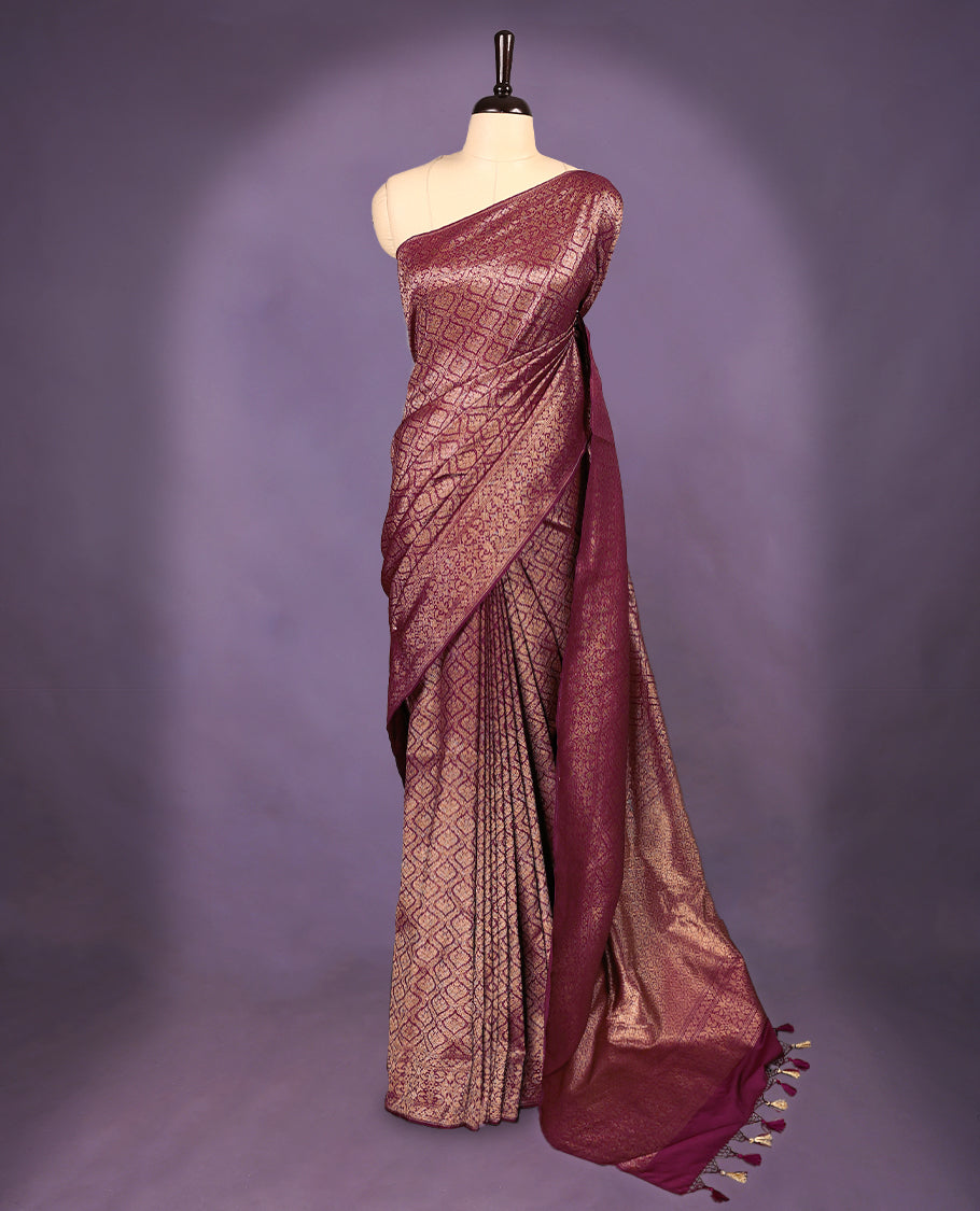 Grape colour semi Banaras Katan saree featuring an antique Gold zari jacquard body, complemented by a self colour traditional border with a floral kodi design, paired with a matching blouse