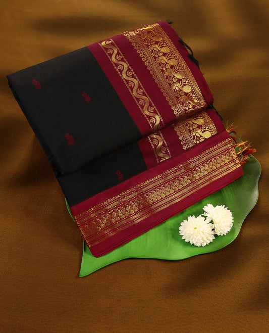 Pure Black colour mixed Kalyani cotton saree featuring Maroon zari motifs throughout the body, paired with a Maroon colour traditional border and pallu, with matching blouse