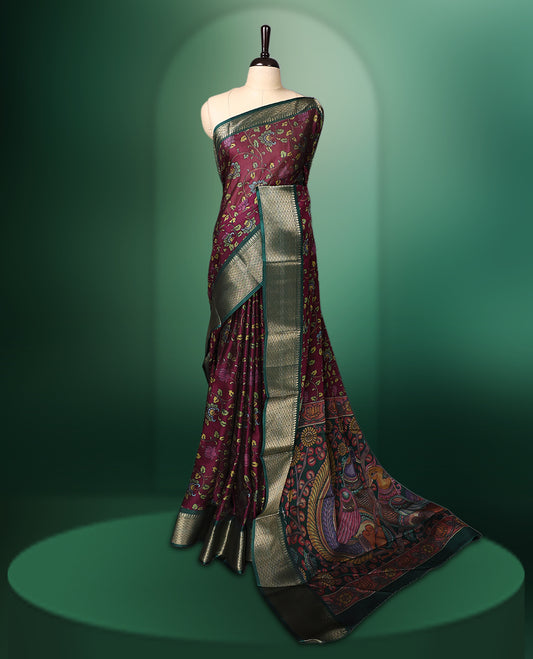 Rich Grape colour saree featuring intricate floral prints across the body, highlighted with a woven Green zari border, complemented by an artistic Kalamkari inspired pallu design, and paired with a matching blouse