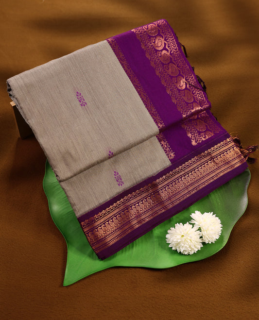 Grey colour mixed Kalyani cotton saree featuring Magenta zari Motifs throughout the body, paired with a Grape colour traditional border and pallu, with matching blouse
