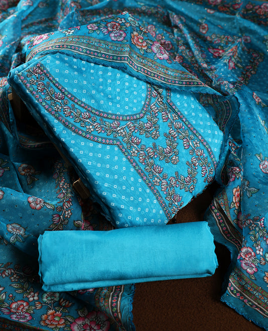 Turquoise blue churidhar material adorned with delicate floral, stone and vine prints, enhanced by a contrast border & Paired with a plain matching bottom, perfect for festive wear and casual elegance.