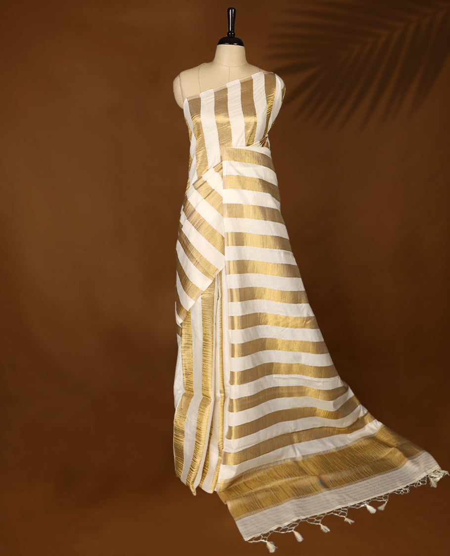 Elegant white colour sotf  Tussar Kerala saree featuring Gold Zari Bold stripes on body, Rich Pallu, Paired with matching blouse offering a classic and graceful look