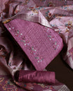 Onion pink colour churidhar material adorned with floral embroidery and sewn glass beads on the yoke, paired with a plain bottom and same colour dupatta featuring floral prints.