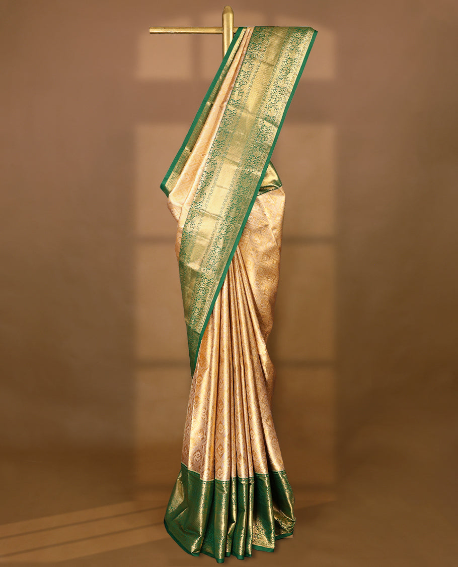 Gold colour tissue brocade saree with gold and silver zari flower and Diamond pattern on body, gold zari floral kodi work Green border, rich matching pallu with Antique zari motifs, paired with matching blouse.