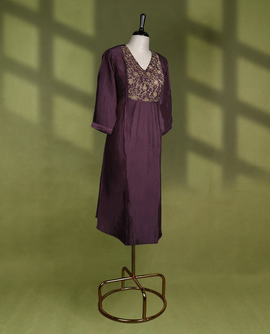 Deep Pastel Purple colour kurti with a V neckline and three quarter sleeves, featuring intricate golden embroidery on the bodice and soft pleats