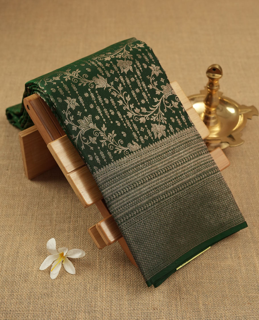 Bottle green colour Kanchipuram pattern Manthrakodi saree featuring kodi floral antique zari jacquard all over, geometric turning border and self zari blouse piece.