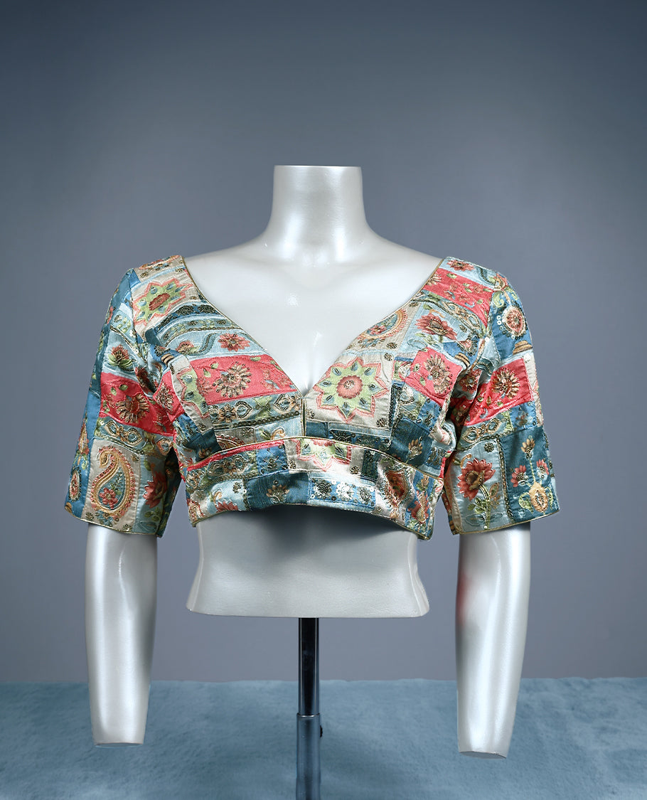 Multicolour V neck padded readymad blouse with elbow length sleeves, featuring an intricate patchwork style floral and paisley brocade pattern in shades of coral pink, teal blue, ivory, and gold.