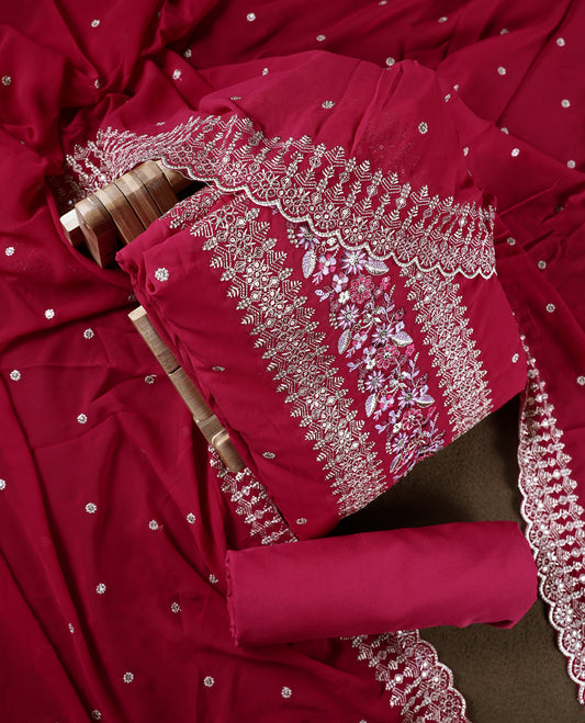 Pinkish red colour churidhar material beautifully designed with golden floral embroidery and multicolour thread highlights, paired with a plain matching bottom and an elegant embroidered dupatta.