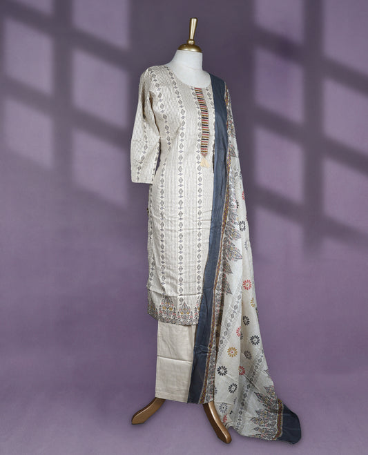 Ivory colour salwar set with vertical stripe and geometric print on the kurta, featuring subtle tassel detail at the neck, paired with plain bottom and a printed dupatta in ivory and slate grey tones.