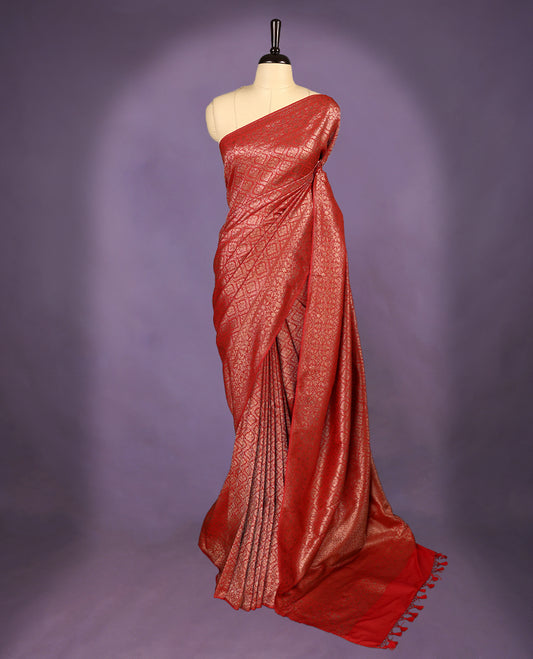 Deep Red colour semi Banaras Katan saree featuring an antique Gold zari jacquard body, complemented by a self colour traditional border with a floral kodi design, paired with a matching blouse
