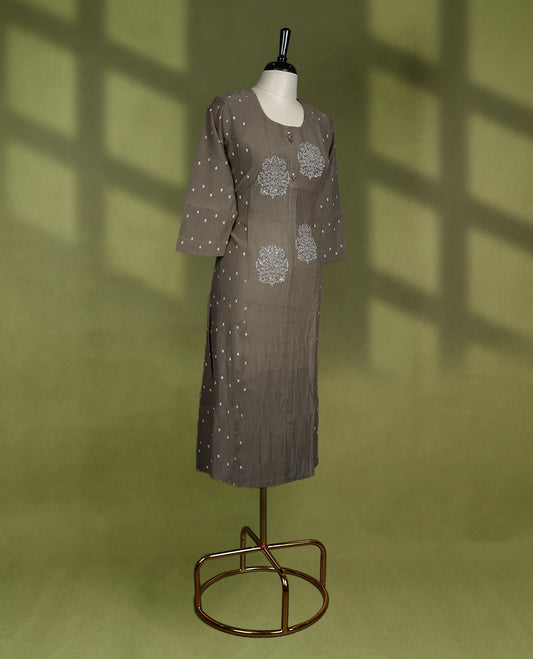 Chic brown colour kurti featuring a round neckline, three quarter sleeves, delicate white floral motifs on the front, and subtle polka dot accents on the sleeves and side panels