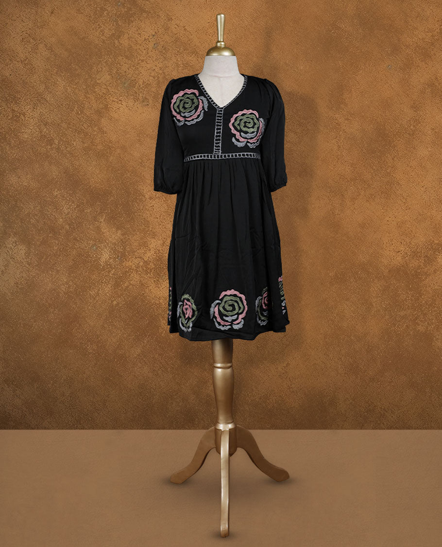 Black knee-length A-line dress with V-neckline, pastel spiral floral embroidery on yoke and hem, and elbow-length gathered sleeves.