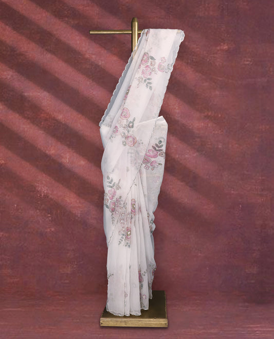 White colour pure organza saree featuring Multi Colour floral prints with intricate bead and sequin work across the body, adorned with a matching embellished border, complemented by a worked pallu and paired with a heavily worked matching blouse.
