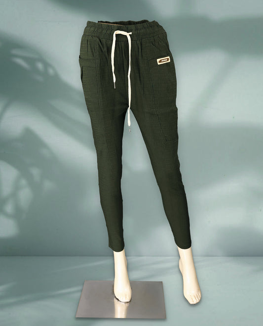 Deep Olive green colour jogger style pants crafted from textured fabric, featuring a drawstring waistband, patch pockets, and a sporty label detail