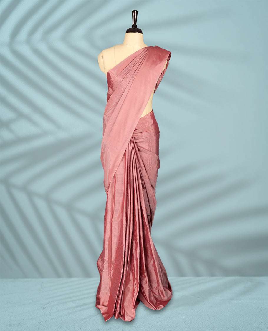 Peach pink colour semi silk saree featuring subtle textured checks on the body, complemented by a self-tone border, and comes with a matching blouse.