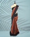 Rich chocolate brown Colour semi silk saree features elegant golden zari check patterns, beautifully contrasted by a sleek black border, and comes with a matching blouse.