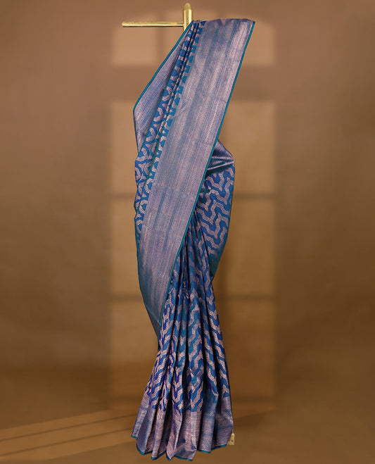 Peacock Blue Colour Manthrakodi saree featuring an antique zari Banarasi design on the body, complemented by a self coloured traditional border and a matching self coloured blouse.