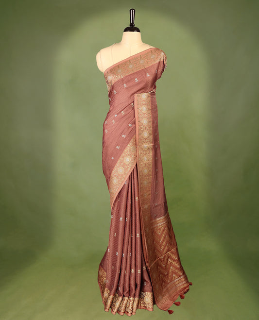 Deep Pastel Brown colour pure Banaras crepe saree showcases elegant silver zari Flower Motifs all over the body, a traditional Banarasi gold zari border, a rich intricately woven pallu, and comes with a matching blouse.